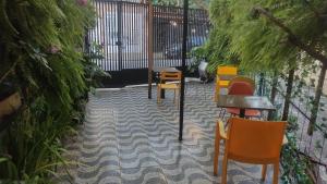 a patio with chairs and tables and a fence at Pousada Casa dos Gattos - Próx ao Aeroporto Guarulhos in Guarulhos