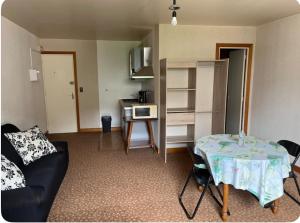 a living room with a table and a kitchen at Studio meublé tout confort in Bourbonne-les-Bains +10 photos