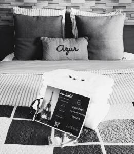 een zwart-witte foto van een bed met een boek erop bij La Clef du Bonheur - 9 Min de Disney Jardin privatif in Bailly-Romainvilliers