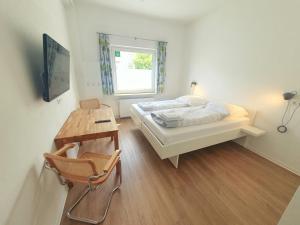 una camera con letto, scrivania e finestra di Aparthotel Sanni a Brema
