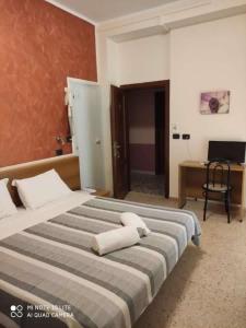 ein Schlafzimmer mit einem großen Bett mit zwei Handtüchern darauf in der Unterkunft Hotel Prestige 3 Stars in Rimini