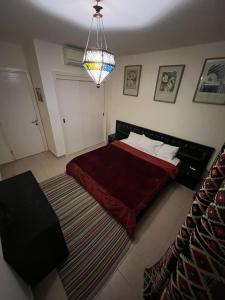 1 dormitorio con 1 cama con manta roja en Marasi Catania, en El Cairo
