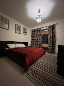 una camera da letto con un grande letto con una coperta rossa di Marasi Catania a Il Cairo