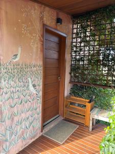 a door to a house with a painting on the wall at Pousada Terra dos Pássaros in São Bento do Sapucaí