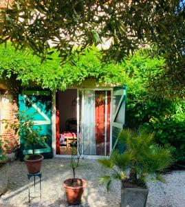 una casa con una puerta de cristal y algunas plantas en La chambre de Lau en Noé