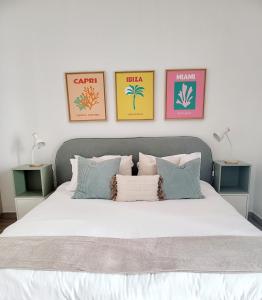 1 dormitorio con 1 cama blanca y 4 cuadros en la pared en Yas Island canal 2- where luxury meets comfort next to Formula 1 en Abu Dabi