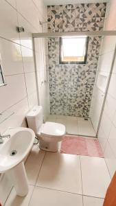 biała łazienka z toaletą i umywalką w obiekcie Sagui Hostel w mieście Florianópolis