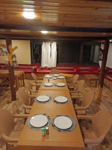 a long wooden table in a room with chairs at Dana luxury huts in Dana