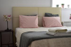 1 dormitorio con 1 cama con almohadas rosas en Green House, en Oporto