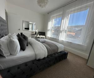 伯恩茅斯的住宿－5 min from the beach En suite room in Guest house，一间卧室设有一张大床和两个窗户。