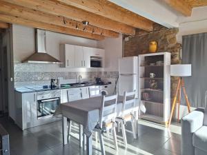 a kitchen with white appliances and a table and chairs at Dúplex Sant Martí in Àger