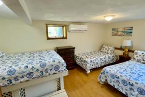 a bedroom with two beds and a window at Birch Circle Beach House in Ogunquit