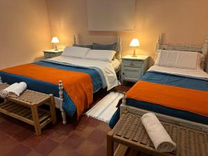 1 dormitorio con 2 camas, 2 sillas y lámparas en Casa Los Nogales en Cafayate