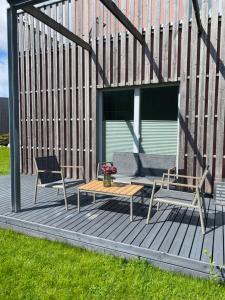Dos sillas y una mesa en una terraza de madera. en YahtClub Apartment, en Kuressaare