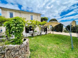 a tent set up in a yard in front of a house at Le domaine des Oliviers ALES Piscine Jacuzzi Sauna in Alès