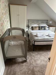 Higham Ferrersにある3 Bed. Sleeps 5. Higham Ferrers. Free Car Charger.のベッドルーム(ベッド1台、ベビーベッド1台付)