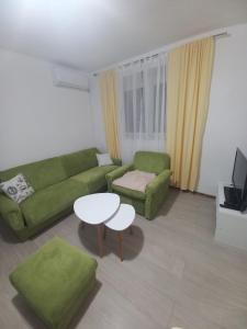 sala de estar con sofá verde y mesa en Apartman Vera, en Bileća