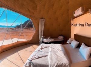 um quarto com uma cama e uma grande janela em Katrina Rum camp em Wadi Rum
