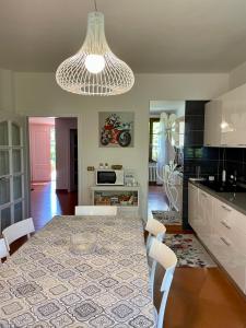 a kitchen with a dining table and a chandelier at Villa Elisa in Scarperia