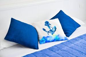 a bed with two blue pillows on it at La Marina B&B in Civitavecchia