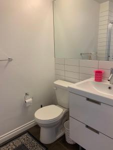 a white bathroom with a toilet and a sink at Best Choice Apartment in Vancouver