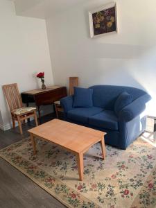 a living room with a blue couch and a coffee table at Best Choice Apartment in Vancouver