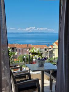 a table on a balcony with a view of the ocean at Apartments Tomaš in Makarska