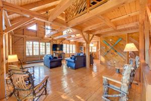 una gran sala de estar con paredes de madera y techo de madera. en Exquisite Cabin with Deck and Fire Pit, 10 Mi to Lake, en Athol