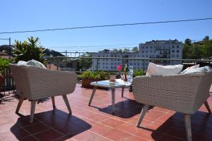a patio with two chairs and a table on a roof at Green House in Porto