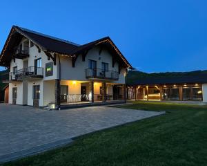 a large house with a driveway in front of it at Pensiunea Andres in Sovata