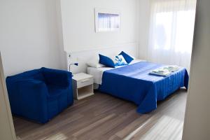 a bedroom with a blue bed and a chair at La Marina B&B in Civitavecchia