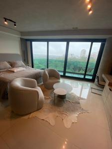 a large bedroom with a bed and a table and chairs at Mansión Botánico Luxury Buenos Aires in Buenos Aires
