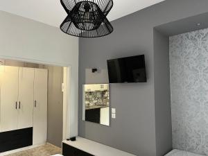 sala de estar con TV y lámpara de araña en O' Kipos en Mythimna