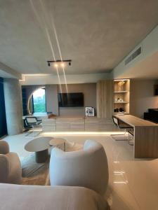 a living room with tables and chairs and a tv at Mansión Botánico Luxury Buenos Aires in Buenos Aires
