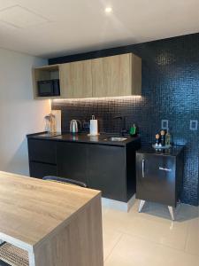 a kitchen with black cabinets and a counter top at Mansión Botánico Luxury Buenos Aires in Buenos Aires