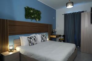 a bedroom with a large bed and a blue wall at Modern 5-Bedroom Apartment Central Malta in Mosta