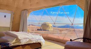 a bedroom with a view of the desert through a window at Katrina Rum camp in Wadi Rum