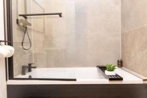 a bathroom with a bath tub with a plant in it at The Berriman Collection Stylish 2 Bedroom Apartment in Cardiff