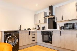 a kitchen with a washer and dryer in it at The Berriman Collection Stylish 2 Bedroom Apartment in Cardiff +22 photos