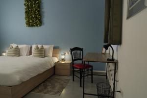 um quarto com uma cama e uma mesa com uma cadeira em Modern 5-Bedroom Apartment Central Malta em Mosta
