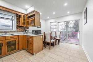 una cocina con armarios de madera y una mesa con sillas. en Littlewood Properties en Toronto