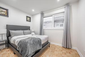 1 dormitorio con cama y ventana en Littlewood Properties, en Toronto