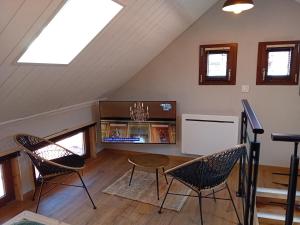 a living room with a table and chairs in a attic at Le Rêve de l'Ours in Annecy