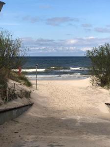 una playa de arena con el océano en el fondo en Domki Energetyk en Pogorzelica