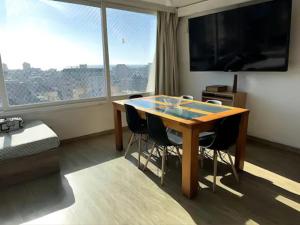 um quarto com uma mesa com cadeiras e uma grande janela em Panorámic Mavericks-chile com viña-Valparaíso em Viña del Mar