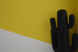 a cactus on a wall next to a yellow wall at Modern 5-Bedroom Apartment Central Malta in Mosta