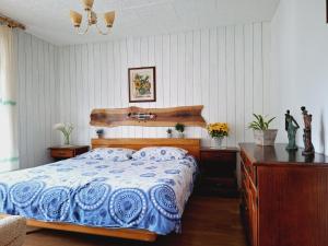 Un dormitorio con una cama azul y blanca y un escritorio en Apartma Ferjan en Žaga