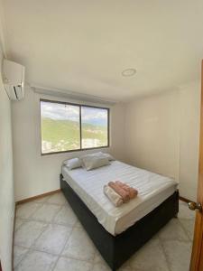 a bedroom with a large bed with a window at Edificio el peñon in Santa Marta