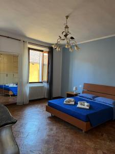 a bedroom with a blue bed and a large window at Casa Regina in Dongo