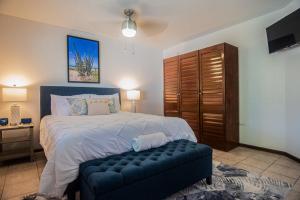 a bedroom with a large bed with a blue ottoman at Cas Amigos Villa in Palm-Eagle Beach